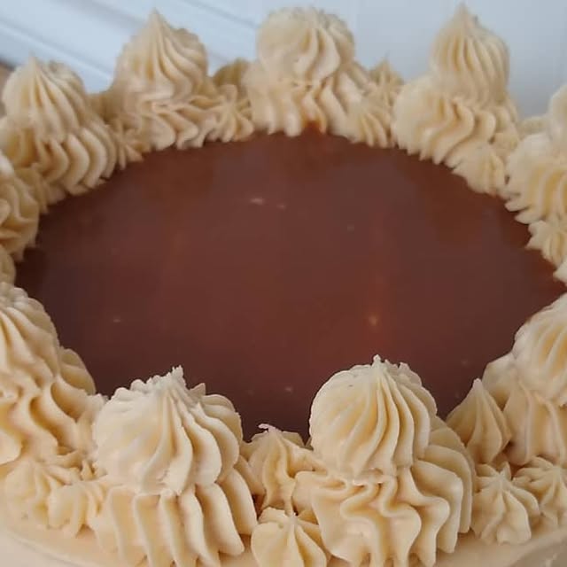Cake with a glossy caramel top ringed by piped caramel buttercream stars